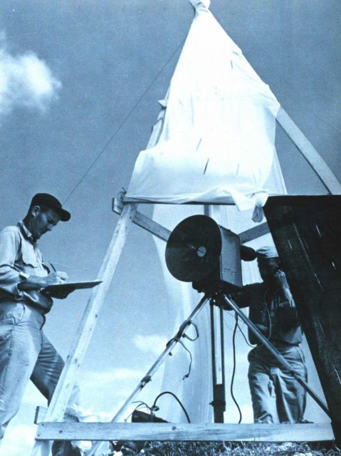 Charles Kearse, Chief Electronics Technician on the EXPLORER records tellurometer distance measurements observed by Commander Ray Stone at Swan Island Picture