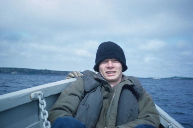 Unidentified crewman returning to PATHFINDER in bow of whaleboat. Picture