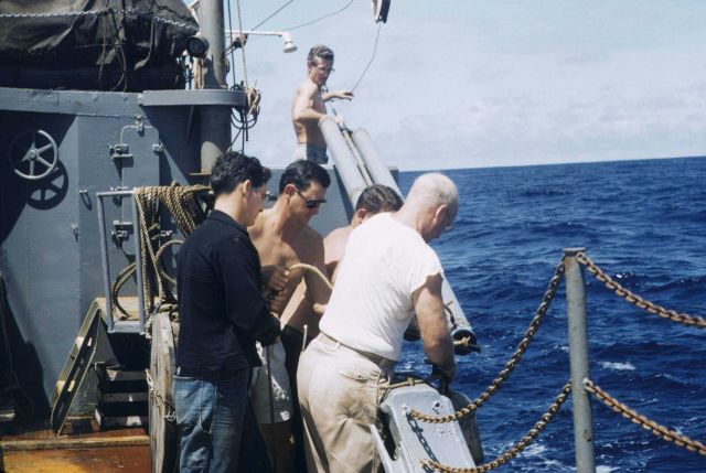 Fisheries scientist Townsend Cromwell standing above and behind scientists while launching scientific gear. Picture