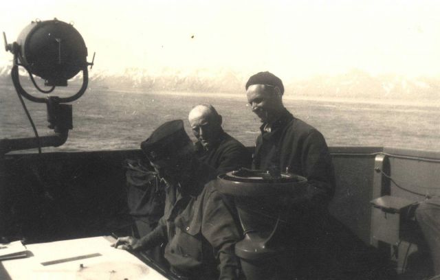 Commander William Malnate at navigator's table with Boatswain Peterson in center and Lt Picture