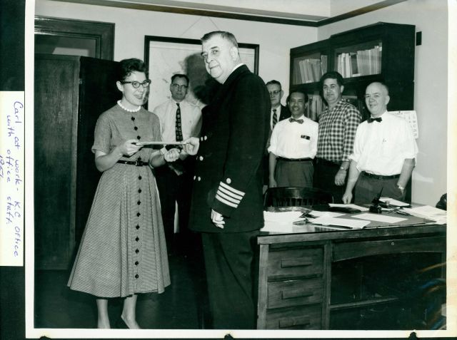 CAPT Carl Mast presenting award to member of office staff in Kansas City Regional Office. Picture
