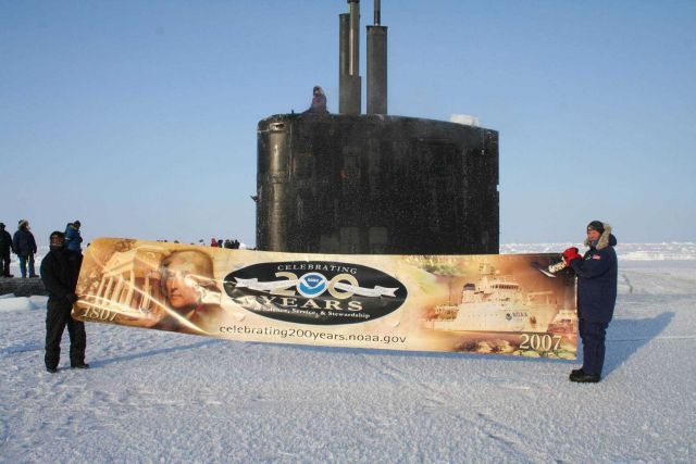 Commander Mike Bernacchi (right), commanding officer of the nuclear-powered attack submarine USS Alexandria, and a shipmate join NOAA's 200th celebrat Picture