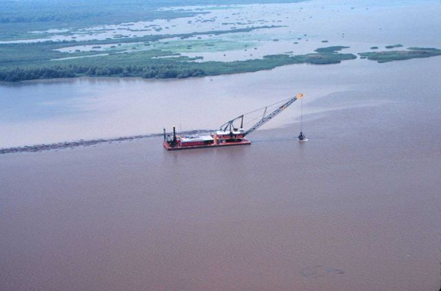 A bucket dredge, the Captain Bufford Berry, working to create the containment dike. Picture