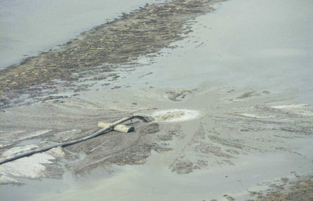 Discharge pipe from dredge depositing sediment into march creation area. Picture