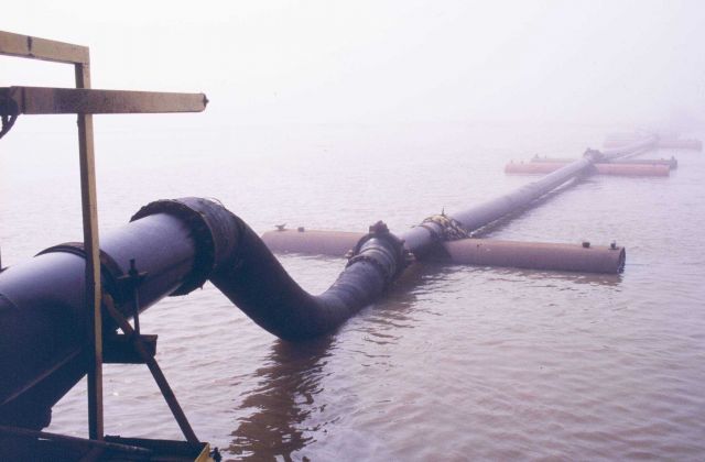 Dredged sediments being pumped through a pipeline toward the marsh creation disposal area. Picture