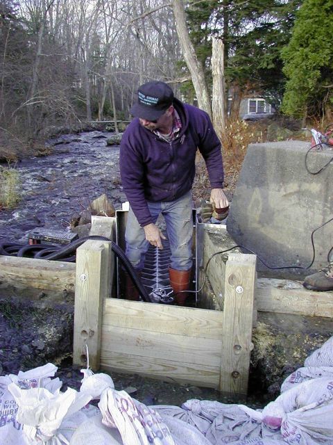 A worker fits the Alaskan Steep Pass into the notch in the dam. Picture