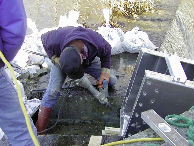 Workers fit the ladder into place and secure it into the notched dam. Picture