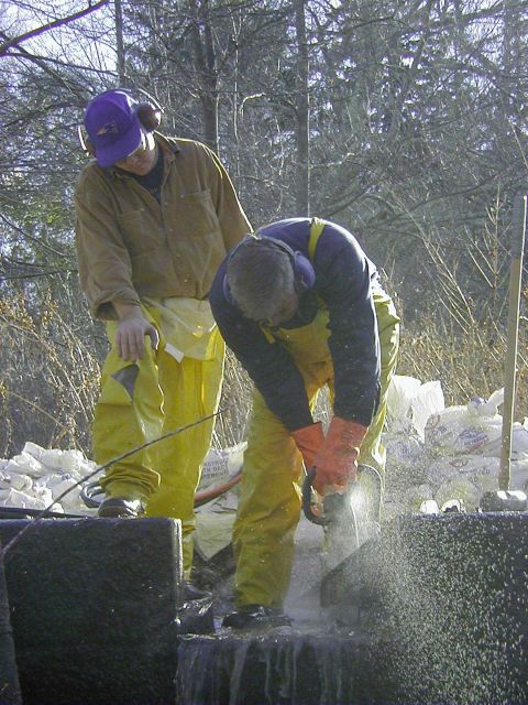 A close up of two workers notching the dam Picture