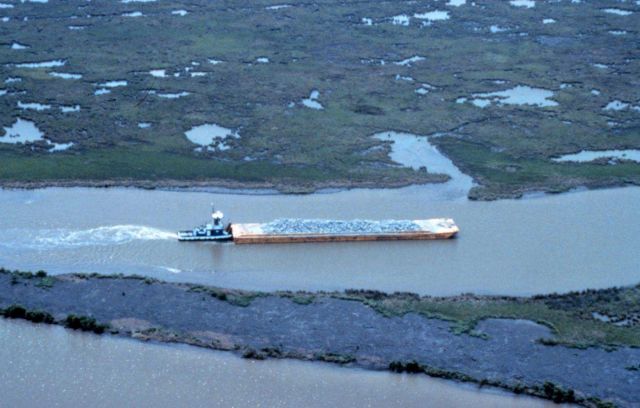 An aerial view of the tug loaded with rock traveling up Locust Bayou. Picture
