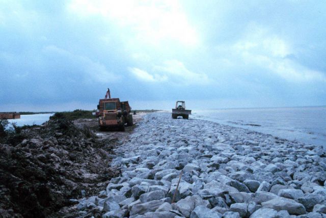 A view of the rock armored beach with construction equipment in the background. Picture
