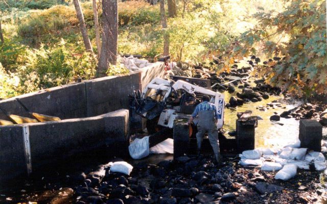 Removing an existing pad to lower the fish entranceway at the restoration site. Picture