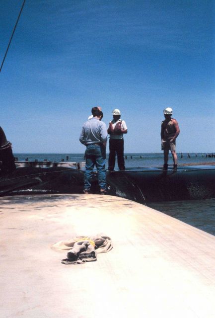 The crew discussing the filling of geotubes. Picture