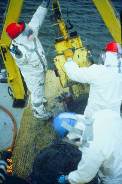 Workers dressed in full hazmat gear conduct research to determine the level of contaminants or PCB levels. Picture