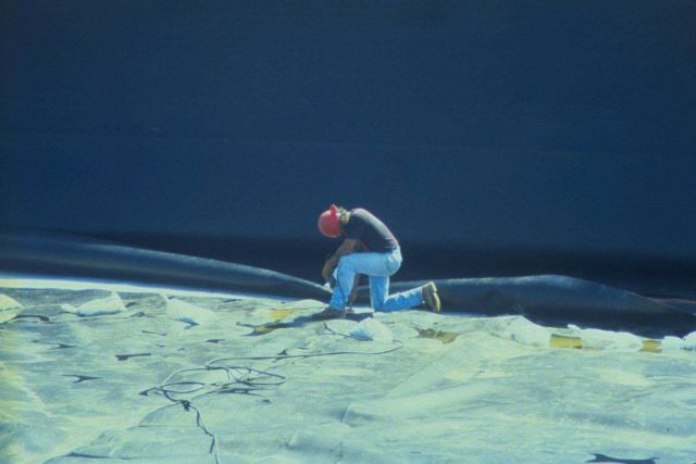 Welding the pieces of fabric together at the bottom and sides of the combined disposal facility. Picture