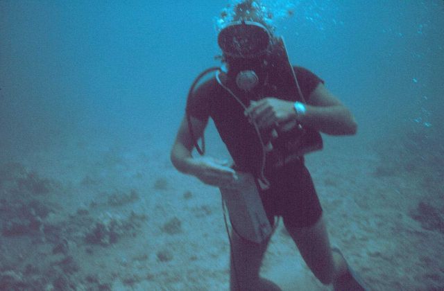 A diver equipped with underwater tape recorder, wetsuit, watch for determining dive time. Picture