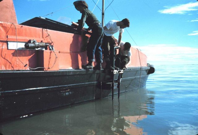 Securing transducer to side of survey launch on a warm Arctic summer day. Picture