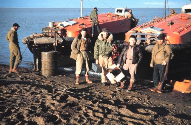 Launch crews with their boats - Lieutenant Commander Marv Paulson in green coat in center. Picture