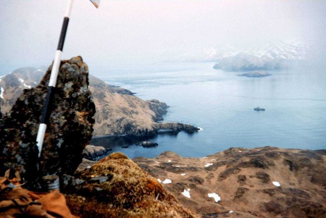A survey marker on Kagalaska Island with the PATHFINDER far below Picture