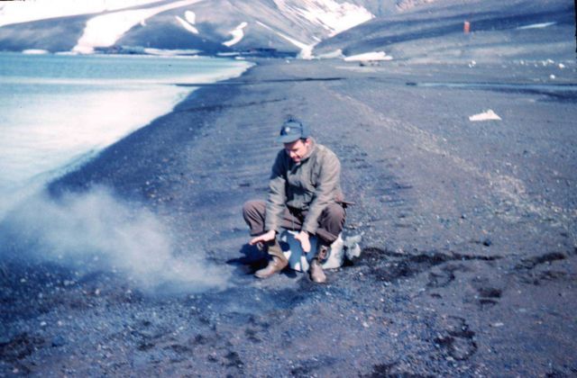 Harley Nygren warming his hands on a seaside fumarole on Deception Island Picture