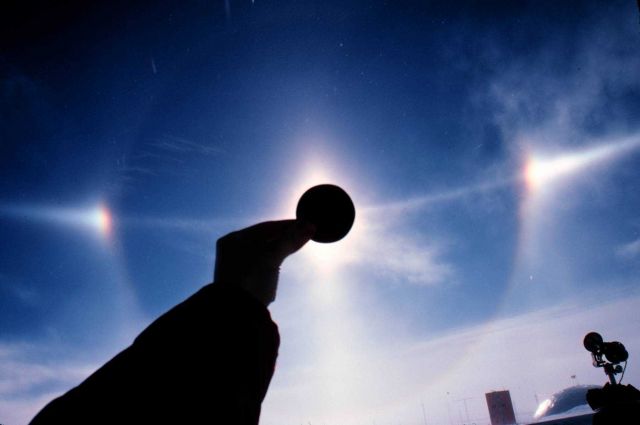 Small halo, sun dogs, and arc of much larger halo nearly bisecting smaller halo. Picture