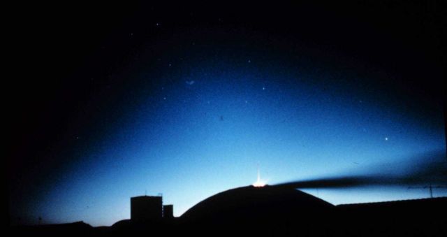Polar night has arrived - geodesic dome silhouetted by bluish aurora australis Horizontal line emanating to right from geodesic dome is exhaust from g Picture