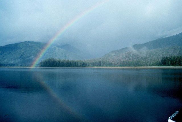 An Alaskan rainbow - note reflection on the water. Picture