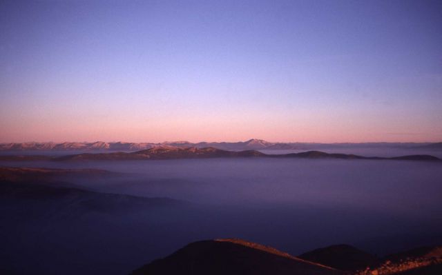 Sunrise illuminating peaks and ridges with smoke inversion west from Mt Washburn Picture