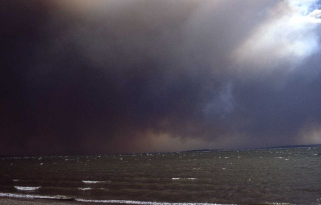Dense black smoke over white capped Yellowstone Lake Picture