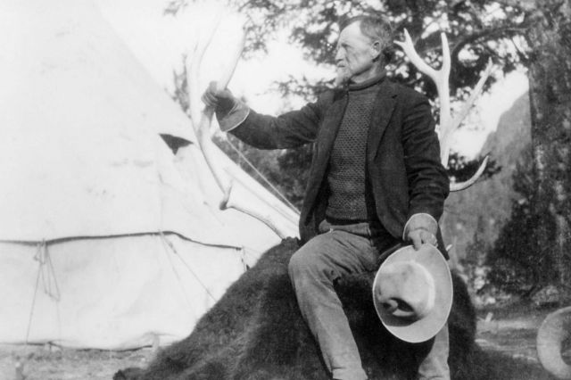 Man sitting on bison robe at T Roosevelt's camp Picture