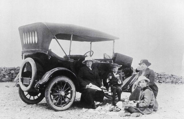 Tourists eating beside car along roadside Picture