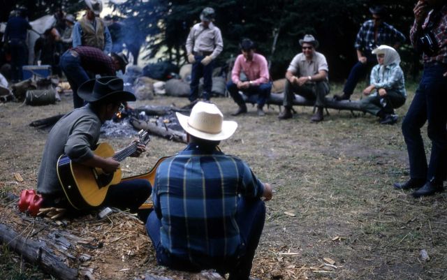 Guitarist by campfire at backcountry campsite Picture