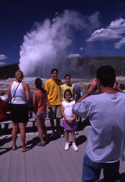 Visitors getting picture taken at Old Faithful geyser Picture