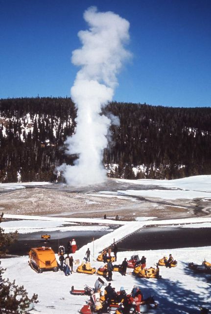 Looking down at snow machines, people & Old Faithful erupting in the winter Picture