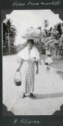 Home from market, a Filipina lady balancing her load. Image