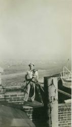 Floyd Risvold with theodolite on top of old brewery near the Navy destroyer piers. Image