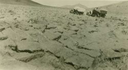 Early C&GS trucks passing through plowed field. Image
