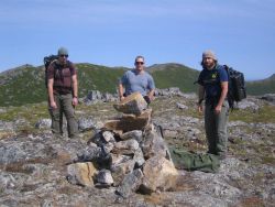 Assistant survey tech Bart Nuckols on left, general vessel assistant Kirk Loeffler, and survey tech Weston Renoud after packing to GPS recording site  Image