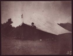 George Davidson standing outside a field tent somewhere in California. Image