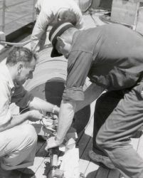 Electronic technician Angelo Ferrara on left checking various electrical connections during Roberts Radio Current Meter deployment. Image