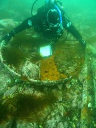 A marine archaeologist taking measurements of the boiler face of the HASSLER. Image