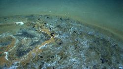 Discolored natural gas and tar seep area. Image