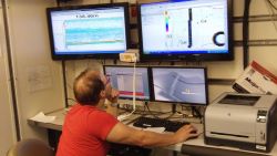 Member of science party on NOAA Ship PISCES monitoring acoustics and navigation. Image