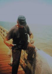 A mullet fisherman mending his net on the Gandy Bridge catwalk Image