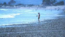 Angler surf fishing on beach. Image