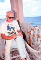 An ancient mariner mending his nets Image