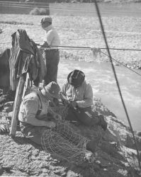 Indian fishermen repairing their nets Image