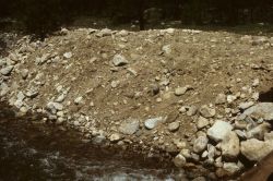 Highway and bridge construction with loose fill that could easily erode into creek. Image