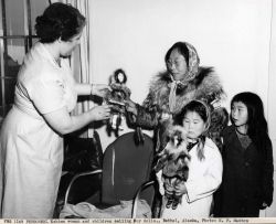 Eskimo woman and children selling fur dolls Image