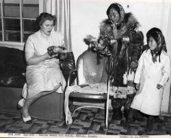 Eskimo woman and children selling fur dolls Image