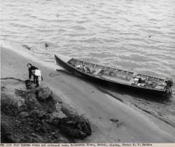 Eskimo woman and outboard boat on the banks of the Kuskokwim River at Bethel. Image